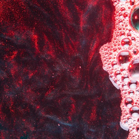 Pink foam on oily red water